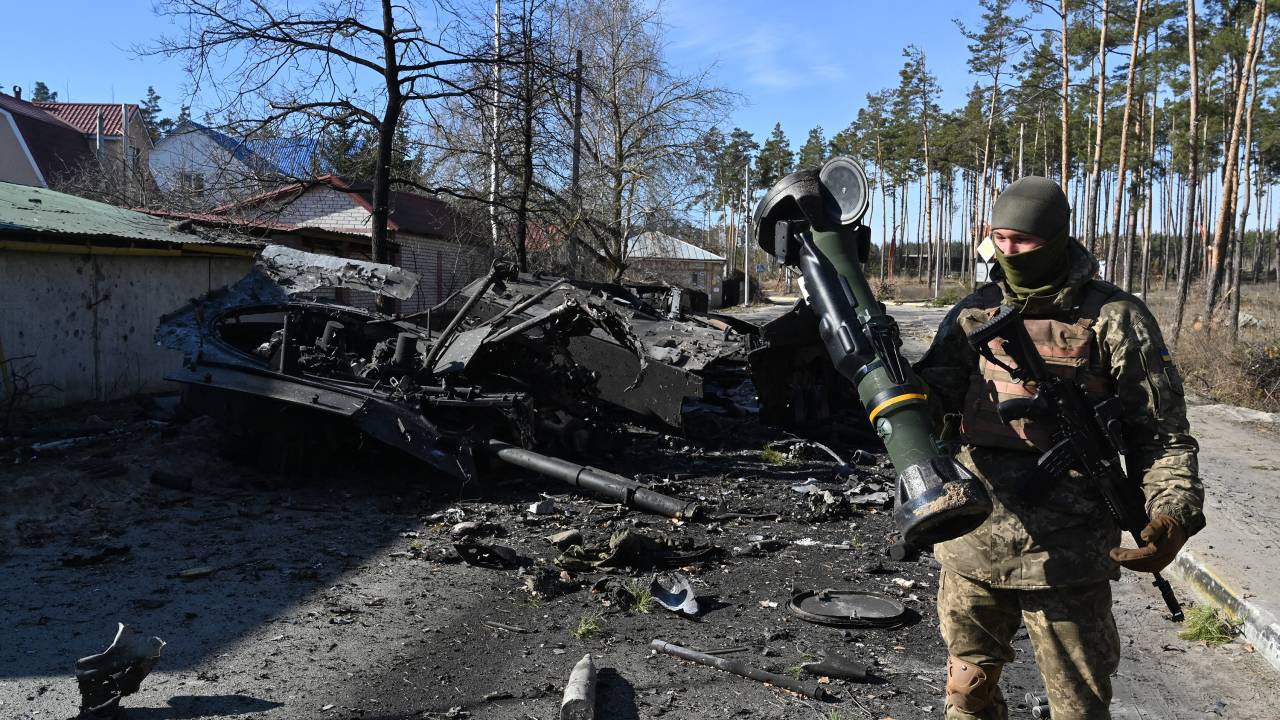 A Ukrainian soldier holds a Next Generation Light Anti-tank Weapon (NLAW) that was used to destroy a Russian armoured personal carrier (APC) in Irpin, north of Kyiv, on March 12, 2022. - Russian forces stepped up the pressure on Kyiv on March 12, 2022. The northwest suburbs of the capital, including Irpin and Bucha, have already endured days of heavy bombardment while Russian armoured vehicles are advancing on the northeastern edge. (Photo by Sergei SUPINSKY / AFP)