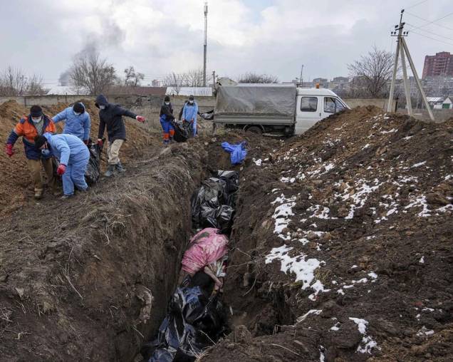 Corpos mortos são colocados em uma vala comum nos arredores de Mariupol, na Ucrânia - Corpos mortos são colocados em uma vala comum nos arredores de Mariupol, na Ucrânia -
