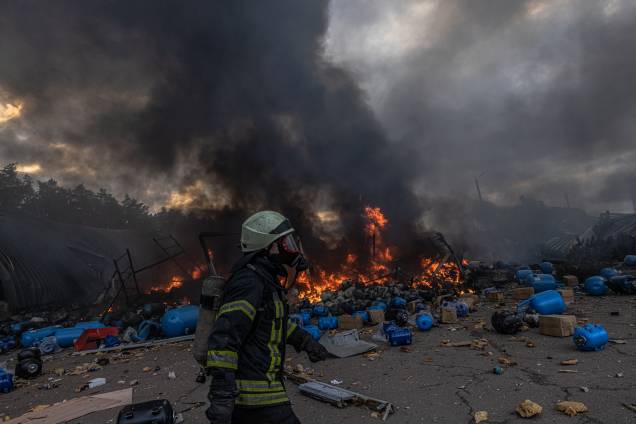 Um bombeiro ucraniano em ação tentando apagar o fogo no depósito com produtos químicos atingidos por bombardeios russos, nos arredores de Brovary - Um bombeiro ucraniano em ação tentando apagar o fogo no depósito com produtos químicos atingidos por bombardeios russos, nos arredores de Brovary -