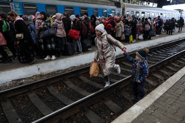 Uma mulher caminha com seu filho nos trilhos da estação de trem de Lviv - Uma mulher caminha com seu filho nos trilhos da estação de trem de Lviv -