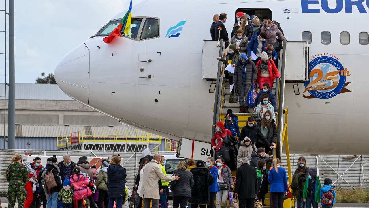 LISBON, PORTUGAL - MARCH 10: Portuguese and Ukrainian flags are displayed from the airplane cockpit as Ukrainian refugees exit the charter flight that brought them to Figo Maduro Military Airport on March 10, 2022 in Lisbon, Portugal. 267 refugees were flown in an operative organized by Ukrainian Refugees NGO in just eight days. Portugal has already received more than 5,000 requests for asylum since Russia's ground forces invaded Ukraine from several directions on February 24 within hours of President Vladimir Putin announcing his decision to launch an assault. Portugal has declared its solidarity with Ukraine and Portuguese President Marcelo Rebelo de Sousa stated his "condemnation" to Russia's "overt and flagrant violation" of international law. (Photo by Horacio Villalobos#Corbis/Corbis via Getty Images)