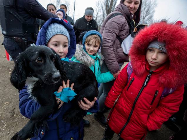 Uma menina segura um cachorro enquanto ela e outros fugindo da Ucrânia passam pela fronteira em Palanca Village, Moldávia - Uma menina segura um cachorro enquanto ela e outros fugindo da Ucrânia passam pela fronteira em Palanca Village, Moldávia -