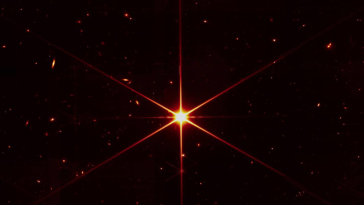 Em um teste de alinhamento, o objetivo era registrar apenas a estrela conhecida como 2MASS J17554042+6551277. Mas os sensíveis instrumentos do James Webb captaram outros astros e galáxias ao fundo da estrela -