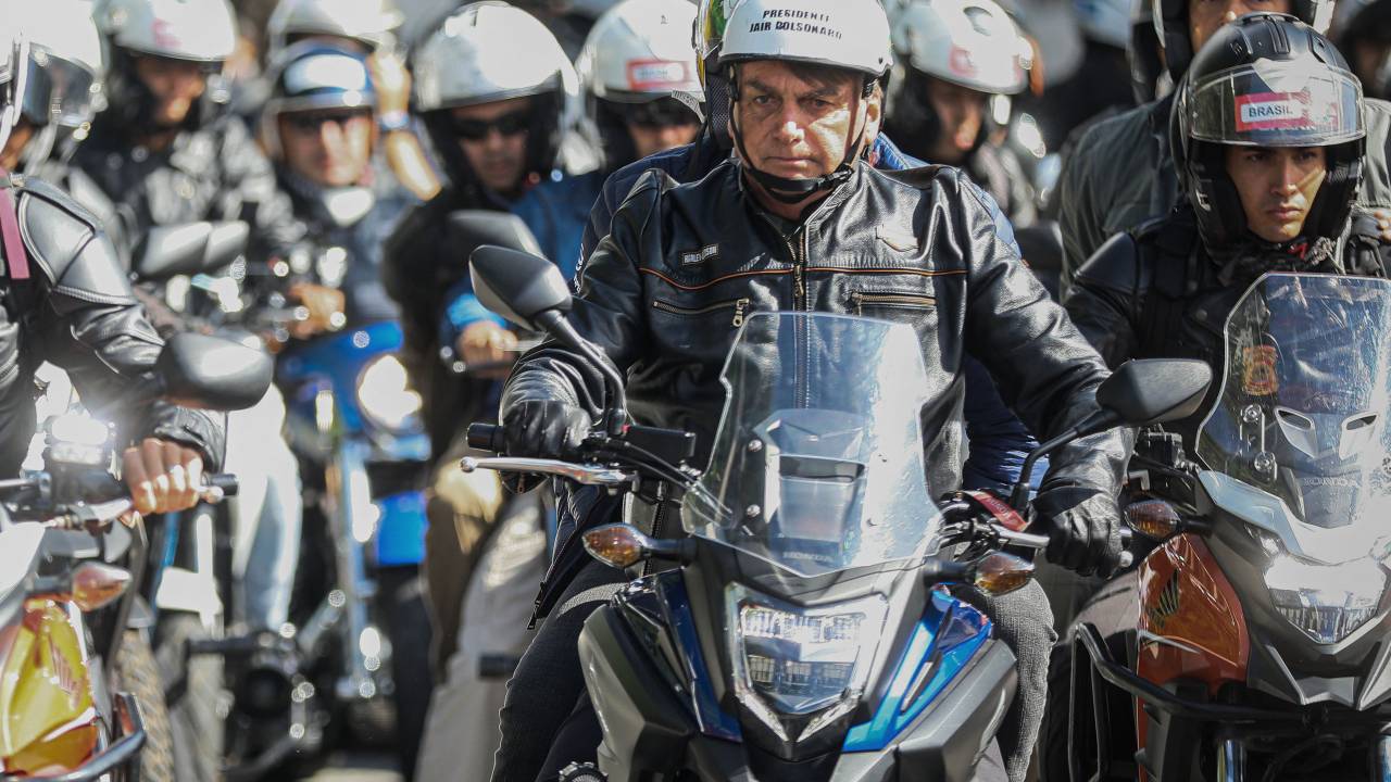 Brazilian President Jair Bolsonaro (L) leads a motorcade rally with his supporters in Sao Paulo, Brazil, on April 15, 2022. (Photo by FILIPE ARAUJO / AFP)