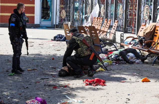 Homens do serviço ucraniano verificam sinais de vida entre vítimas deitadas na plataforma após um ataque russo, na estação ferroviária na cidade oriental de Kramatorsk, na região de Donbass, em 8 de abril de 2022. - Mais Mais de 30 pessoas morreram e mais de 100 ficaram feridas. Homens do serviço ucraniano verificam sinais de vida entre vítimas deitadas na plataforma após um ataque russo, na estação ferroviária na cidade oriental de Kramatorsk, na região de Donbass, em 8 de abril de 2022. - Mais Mais de 30 pessoas morreram e mais de 100 ficaram feridas.
