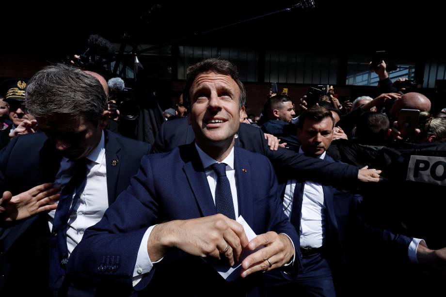 O presidente francês Emmanuel Macron com moradores, durante uma caminhada na praça do mercado Saint-Christophe em Cergy, subúrbio de Paris, França, 27 de abril de 2022.