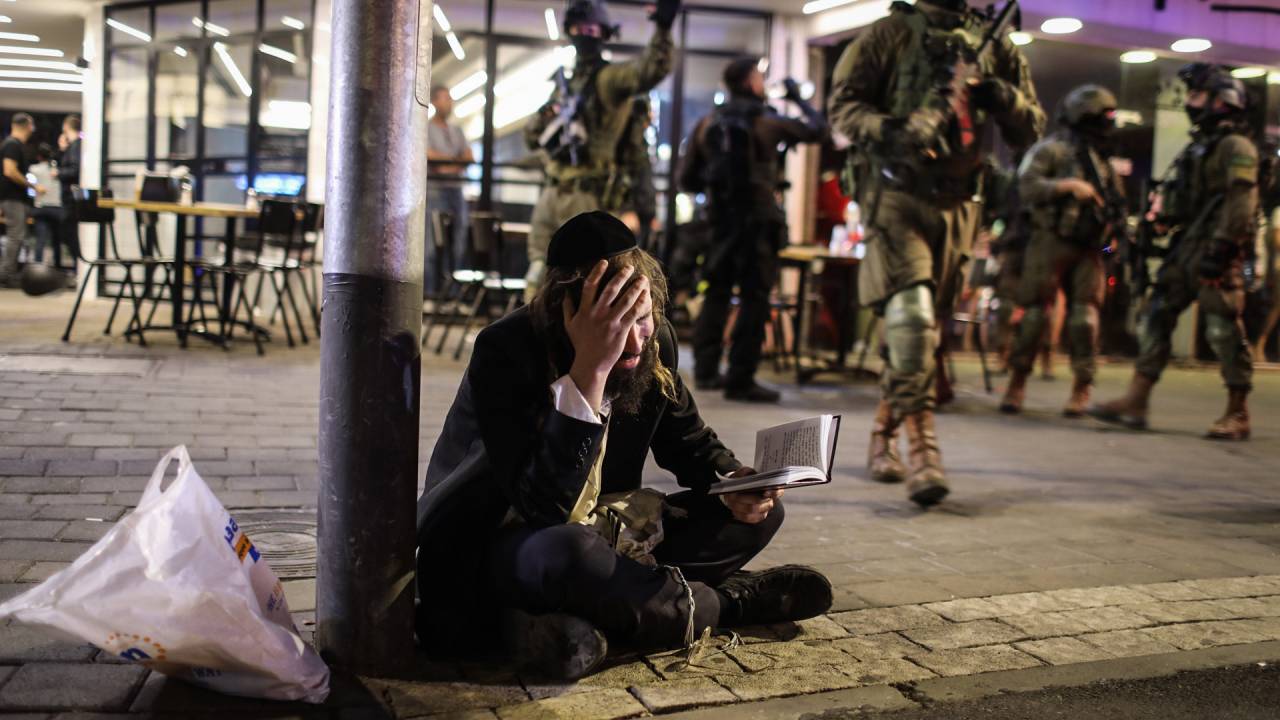 07 April 2022, Israel, Tel Aviv: An Orthodox Jewish man reacts as Israeli security forces search for shooters after a suspected terror attack on Dizengoff Street in central Tel Aviv. At least two people dead and 12 injured in a shooting attack in Tel Aviv's busy central shopping street. Photo: Ilia Yefimovich/dpa (Photo by Ilia Yefimovich/picture alliance via Getty Images)