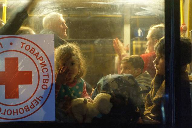 Uma criança olha pela janela de um ônibus enquanto um comboio de 30 ônibus transportando refugiados de Mariupol e Melitopol chega ao centro de Zaporizhzhia - Uma criança olha pela janela de um ônibus enquanto um comboio de 30 ônibus transportando refugiados de Mariupol e Melitopol chega ao centro de Zaporizhzhia -