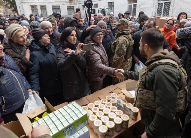 O presidente ucraniano Volodymyr Zelensky conversando com os moradores locais enquanto eles recebem ajuda humanitária - O presidente ucraniano Volodymyr Zelensky conversando com os moradores locais enquanto eles recebem ajuda humanitária -