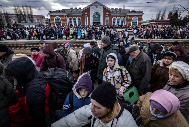 Famílias caminham em uma plataforma para embarcar em um trem na estação central de Kramatorsk - Famílias caminham em uma plataforma para embarcar em um trem na estação central de Kramatorsk -