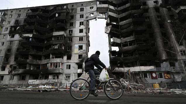 Um ciclista passa por um prédio destruído na cidade de Borodianka, a noroeste de Kiev - Um ciclista passa por um prédio destruído na cidade de Borodianka, a noroeste de Kiev -