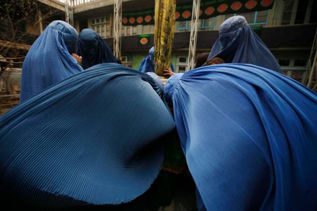Mulheres afegãs beijam bandeiras religiosas xiitas em Cabul, Afeganistão, enquanto os muçulmanos xiitas comemoram a morte do imã Hussein no século VII durante a Batalha de Karbala, no Iraque. Mulheres afegãs beijam bandeiras religiosas xiitas em Cabul, Afeganistão, enquanto os muçulmanos xiitas comemoram a morte do imã Hussein no século VII durante a Batalha de Karbala, no Iraque.