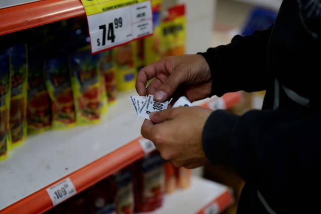 Um comerciante de um supermercado, na cidade de Buenos Aires alterando os preços de produtos. A economia da Argentina sentiu muito os efeitos da pandemia e às restrições sanitárias adotadas para conter a Covid-19. Um comerciante de um supermercado, na cidade de Buenos Aires alterando os preços de produtos. A economia da Argentina sentiu muito os efeitos da pandemia e às restrições sanitárias adotadas para conter a Covid-19.