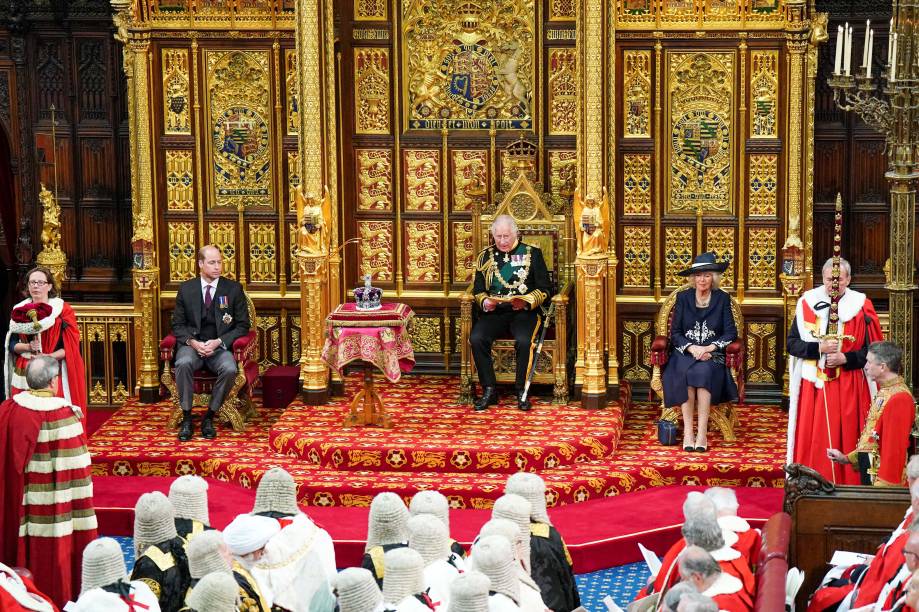 O príncipe britânico Charles, Príncipe de Gales, lê o Discurso da Rainha sentado ao lado da Coroa do Estado Imperial da Grã-Bretanha, Camilla Duquesa da Cornualha e do Britânico Príncipe William, Duque de Cambridge na Câmara dos Lordes, durante a Abertura Estadual do Parlamento, em Londres, em 10 de maio de 2022. O príncipe britânico Charles, Príncipe de Gales, lê o Discurso da Rainha sentado ao lado da Coroa do Estado Imperial da Grã-Bretanha, Camilla Duquesa da Cornualha e do Britânico Príncipe William, Duque de Cambridge na Câmara dos Lordes, durante a Abertura Estadual do Parlamento, em Londres, em 10 de maio de 2022.