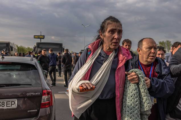 Uma mulher ferida, caminha após desembarcar de um ônibus que trouxe pessoas refugiadas da siderúrgica Azovstal, cidade de Mariupol e arredores para Zaporizhzhia, Ucrânia, 03 de maio de 2022. Uma mulher ferida, caminha após desembarcar de um ônibus que trouxe pessoas refugiadas da siderúrgica Azovstal, cidade de Mariupol e arredores para Zaporizhzhia, Ucrânia, 03 de maio de 2022.