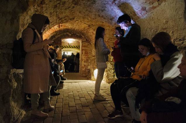 Pessoas se acomodam num porão de um edifício histórico que está sendo usado como abrigo antiaéreo durante um alerta de ataque aéreo na cidade de Lviv, no oeste da Ucrânia. Pessoas se acomodam num porão de um edifício histórico que está sendo usado como abrigo antiaéreo durante um alerta de ataque aéreo na cidade de Lviv, no oeste da Ucrânia.