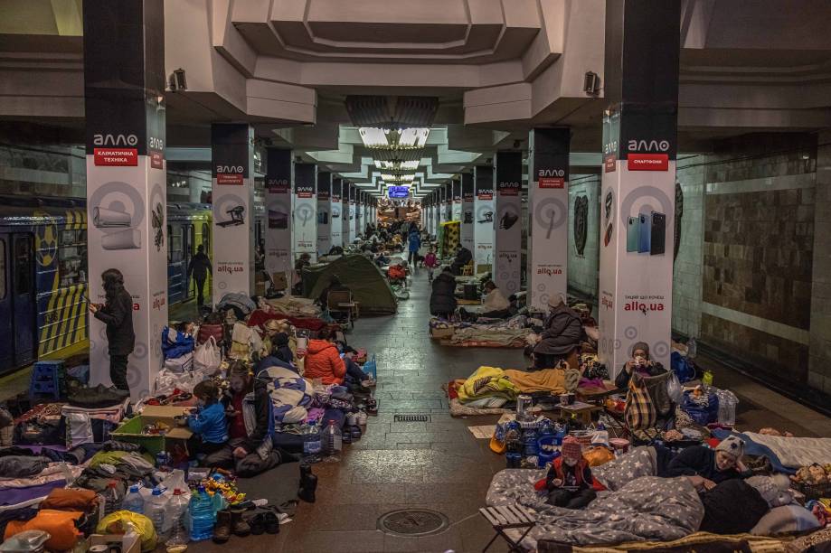 Pessoas dentro de uma estação de metrô usada como abrigo antiaéreo, enquanto o ataque da Rússia à Ucrânia continua, em Kharkiv, nordeste da Ucrânia.