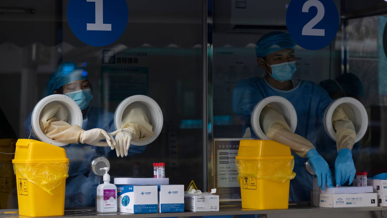 SHANGHAI, CHINA - JUNE 09: Staff members wait at a COVID-19 testing station on June 09, 2022 in Shanghai, China. (Photo by Hugo Hu/Getty Images)
