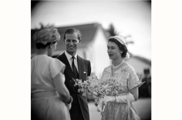 Uma mulher cumprimentando a rainha Elizabeth II e o príncipe Philip e lhe oferece um buquê de flores. Anos 60. Uma mulher cumprimentando a rainha Elizabeth II e o príncipe Philip e lhe oferece um buquê de flores. Anos 60.