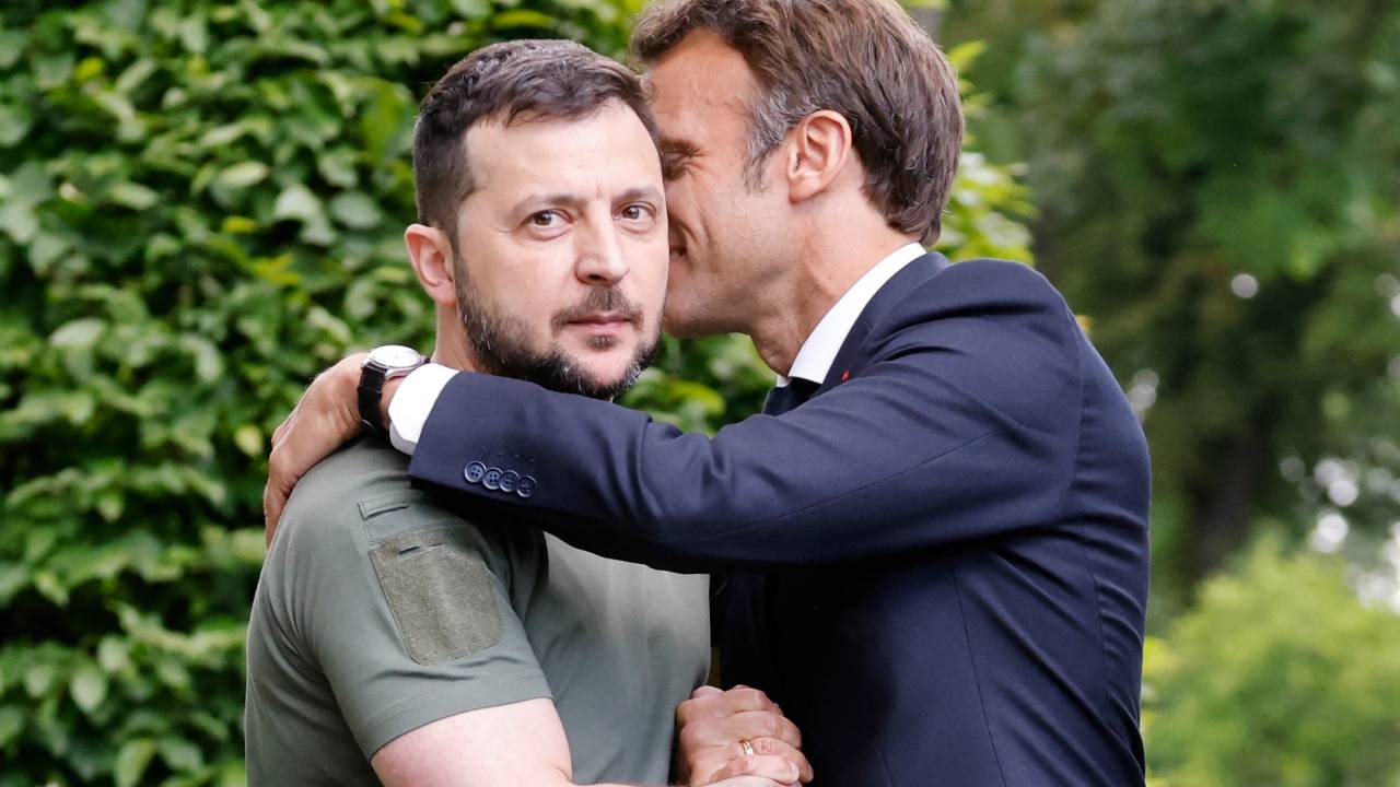 Ukrainian President Volodymyr Zelensky (L) and French Fresident Emmanuel Macron embrace after giving a press conference in at Mariinsky Palace in Kyiv, on June 16, 2022. - The leaders of major EU powers France, Germany and Italy vowed on June 16 to help Ukraine defeat Russia and to rebuild its shattered cities, in a visit to a war-torn Kyiv suburb. (Photo by Ludovic MARIN / POOL / AFP)