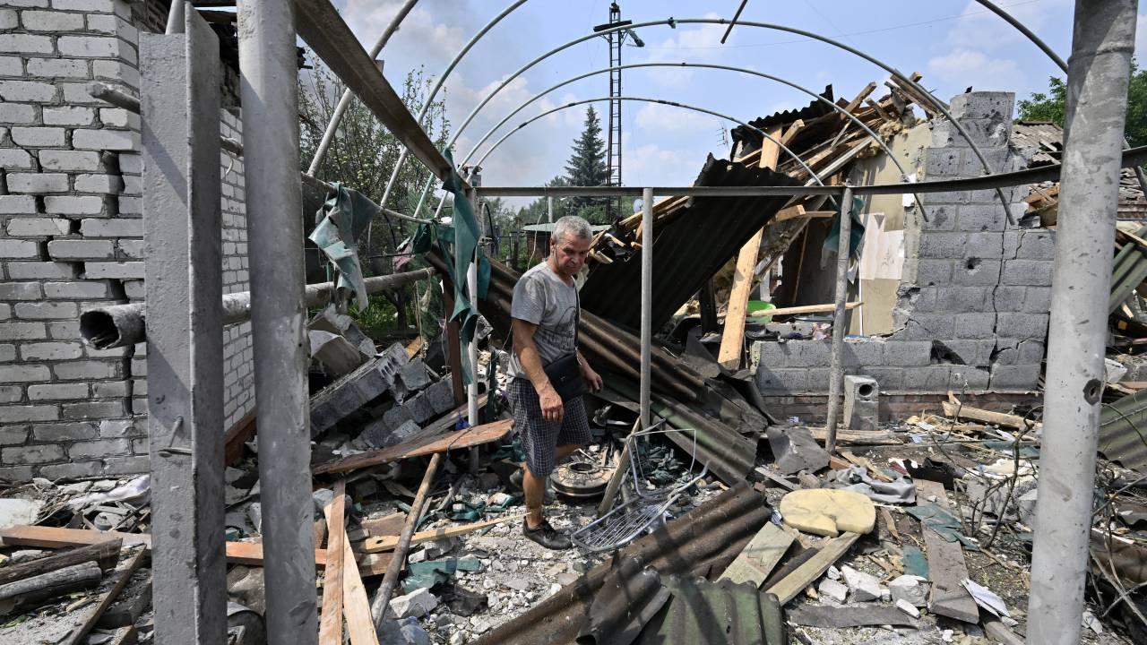 A resident walks among debris next to a destroyed house in Sloviansk on July 4, 2022, the day after a Russian rocket attack. (Photo by Genya SAVILOV / AFP)