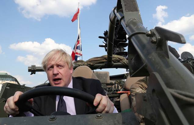 O então secretário de Relações Exteriores da Grã-Bretanha, Boris Johnson, em um veículo militar das forças armadas britânicas baseado em Orzysz, Polônia em 2016. O então secretário de Relações Exteriores da Grã-Bretanha, Boris Johnson, em um veículo militar das forças armadas britânicas baseado em Orzysz, Polônia em 2016.