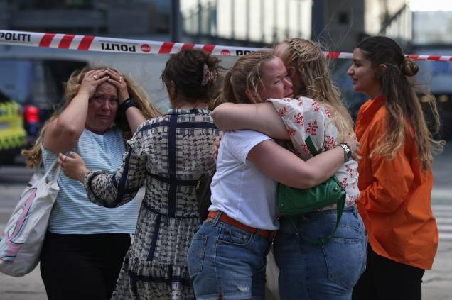 Pessoas se abraçam enquanto a polícia evacua o shopping Fields em Copenhague, Dinamarca, em 03/07/2022, após um atirador efetuar vários disparos, deixando mortos e feridos feridos. Pessoas se abraçam enquanto a polícia evacua o shopping Fields em Copenhague, Dinamarca, em 03/07/2022, após um atirador efetuar vários disparos, deixando mortos e feridos feridos.