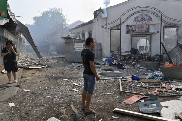 Moradores locais observam lojas destruídas em um mercado local após um ataque com foguete na cidade ucraniana de Sloviansk, em 03/07/2022, em meio à invasão russa da Ucrânia. Moradores locais observam lojas destruídas em um mercado local após um ataque com foguete na cidade ucraniana de Sloviansk, em 03/07/2022, em meio à invasão russa da Ucrânia.