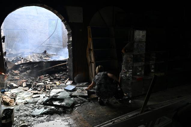 Uma vendedora recolhe algumas mercadorias de uma loja destruída em um mercado local após um ataque com foguete na cidade ucraniana de Sloviansk, em 03/07/2022, em meio à invasão russa da Ucrânia. Uma vendedora recolhe algumas mercadorias de uma loja destruída em um mercado local após um ataque com foguete na cidade ucraniana de Sloviansk, em 03/07/2022, em meio à invasão russa da Ucrânia.
