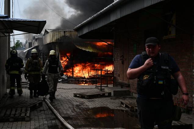 Bombeiros trabalham para controlar as chamas no mercado central de Sloviansk, em 05/07/2022, após um suposto ataque com mísseis em meio à invasão russa da Ucrânia. Bombeiros trabalham para controlar as chamas no mercado central de Sloviansk, em 05/07/2022, após um suposto ataque com mísseis em meio à invasão russa da Ucrânia.