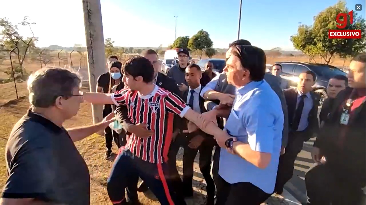 O presidente Jair Bolsonaro segura no braço do youtuber Wilker Leão, na saída do Palácio da Alvorada