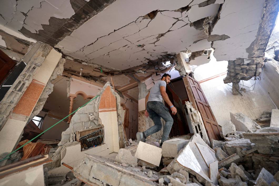 Um palestino caminha em meio aos escombros de sua casa danificada, após ataques aéreos israelenses na cidade de Gaza, em 07 /08/2022. Um palestino caminha em meio aos escombros de sua casa danificada, após ataques aéreos israelenses na cidade de Gaza, em 07 /08/2022.