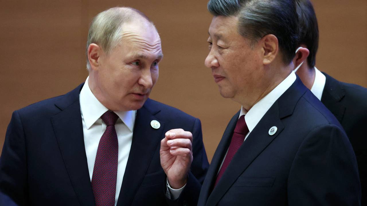 Russian President Vladimir Putin speaks to China's President Xi Jinping during the Shanghai Cooperation Organisation (SCO) leaders' summit in Samarkand on September 16, 2022. (Photo by Sergei BOBYLYOV / SPUTNIK / AFP)
