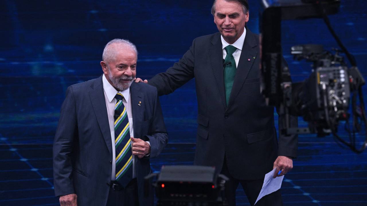 Brazilian former president (2003-2010) and presidential candidate for the leftist Workers Party (PT), Luiz Inacio Lula da Silva (L), and Brazilian President and presidential candidate Jair Bolsonaro (R) gesture during a televised presidential debate in Sao Paulo, Brazil, on October 16, 2022. - President Jair Bolsonaro and former President Luiz Inácio Lula da Silva face each other this Sunday night in the first face-to-face debate, in which they will try to take advantage 14 days before the second round of the presidential elections in Brazil. (Photo by NELSON ALMEIDA / AFP)