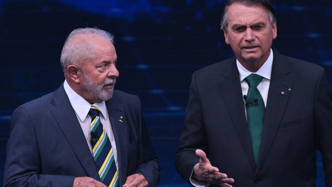 Brazilian President and presidential candidate Jair Bolsonaro (R) speaks next to Brazilian former president (2003-2010) and presidential candidate for the leftist Workers Party (PT), Luiz Inacio Lula da Silva (L), during a televised presidential debate in Sao Paulo, Brazil, on October 16, 2022. - President Jair Bolsonaro and former President Luiz Inácio Lula da Silva face each other this Sunday night in the first face-to-face debate, in which they will try to take advantage 14 days before the second round of the presidential elections in Brazil. (Photo by NELSON ALMEIDA / AFP)