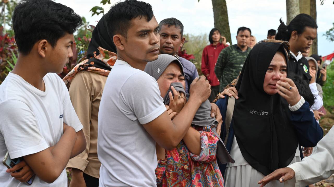 Relatives cry during the funeral of 48-year-old victim Husein, who was killed while building a house, at a village near Cianjur on November 22, 2022, following a 5.6-magnitude earthquake. - The death toll from an earthquake on Indonesia's main island of Java jumped to 268 on November 22, as rescuers searched for survivors in the rubble and relatives started to bury their loved ones. (Photo by ADEK BERRY / AFP)