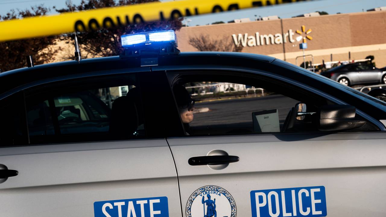 CHESAPEAKE, VA - NOVEMBER 23: A Virginia State Police officer watches the police line set up at the site of Tuesdays fatal shooting at the Chesapeake Walmart Supercenter on November 23, 2022 in Chesapeake, Virginia. Six people, including the suspected gunman, are dead following the Tuesday night shooting. (Photo by Nathan Howard/Getty Images)