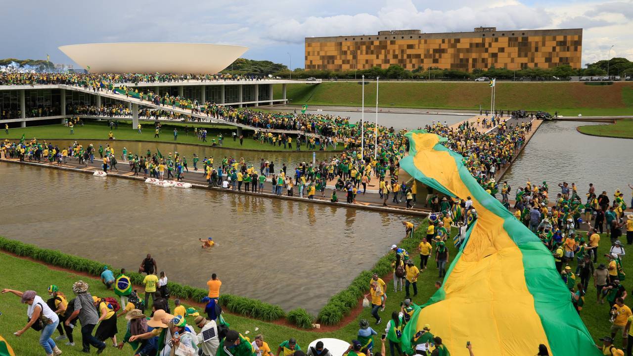 Supporters of Brazilian former President Jair Bolsonaro invade the National Congress in Brasilia on January 8, 2023. - Hundreds of supporters of Brazil's far-right ex-president Jair Bolsonaro broke through police barricades and stormed into Congress, the presidential palace and the Supreme Court Sunday, in a dramatic protest against President Luiz Inacio Lula da Silva's inauguration last week. (Photo by Sergio Lima / AFP)