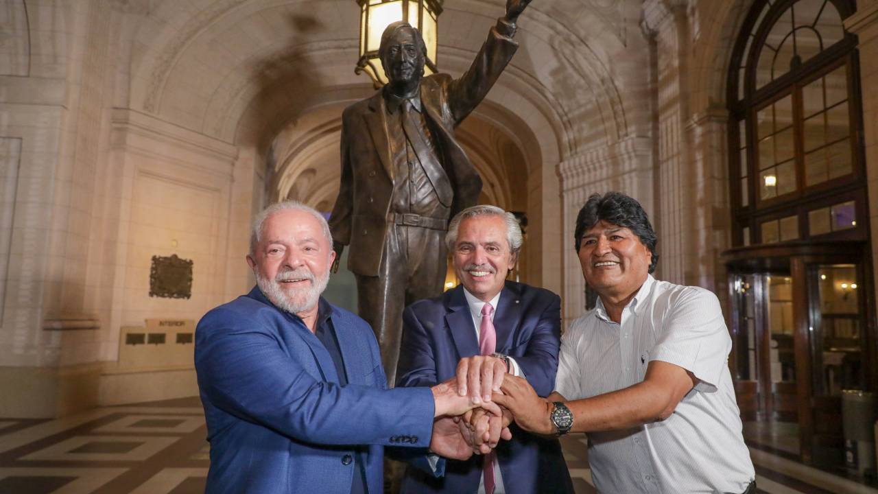 Handout picture released by the Argentinian presidency showing (L to R) Brazilian President Luiz Inacio Lula da Silva, Argentine President Alberto Fernandez, and Bolivian former President (2006-2019) Evo Morales shaking hands in front of a statue of late Argentine President (2003-2007) Nestor Kirchner during the concert of the Argentine-Brazilian brotherhood at Kirchner Cultural Center (CCK) in Buenos Aires on January 23, 2023. - Brazil's President Luiz Inacio Lula da Silva began his first international tour last Sunday with a visit to Argentina and Uruguay with the aim of restoring regional leadership to Brazil after the management of the far-right Jair Bolsonaro. (Photo by ESTEBAN COLLAZO / Argentinian Presidency / AFP) / RESTRICTED TO EDITORIAL USE - MANDATORY CREDIT "AFP PHOTO / ARGENTINIAN PRESIDENCY / ESTEBAN COLLAZO" - NO MARKETING NO ADVERTISING CAMPAIGNS - DISTRIBUTED AS A SERVICE TO CLIENTS