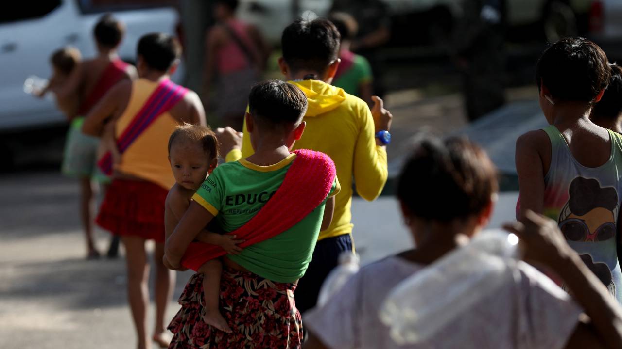 Yanomami indigenous people walk inside the Brazilian Air Force Field Hospital built inside the Indigenous Health House at the city of Boa Vista, Roraima state, Brazil, on January 30, 2023. - At a hospital in the Brazilian Amazon, Yanomami children convalesce on hammocks. The cases of malnutrition and child malaria in this indigenous ethnic group skyrocketed, prompting the government to declare a health emergency. (Photo by MICHAEL DANTAS / AFP)