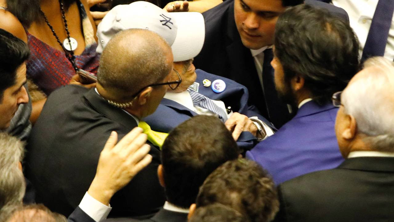 Brazilian deputy Benedito de Lira (C), father of the president of the Chamber of Deputies Arthur Lira, is helped after suffering a faint spell during the inauguration ceremony of the new Brazilian deputies, at the plenary of the Chamber of Deputies in the National Congress, in Brasilia, on February 1, 2023. (Photo by Sergio Lima / AFP)