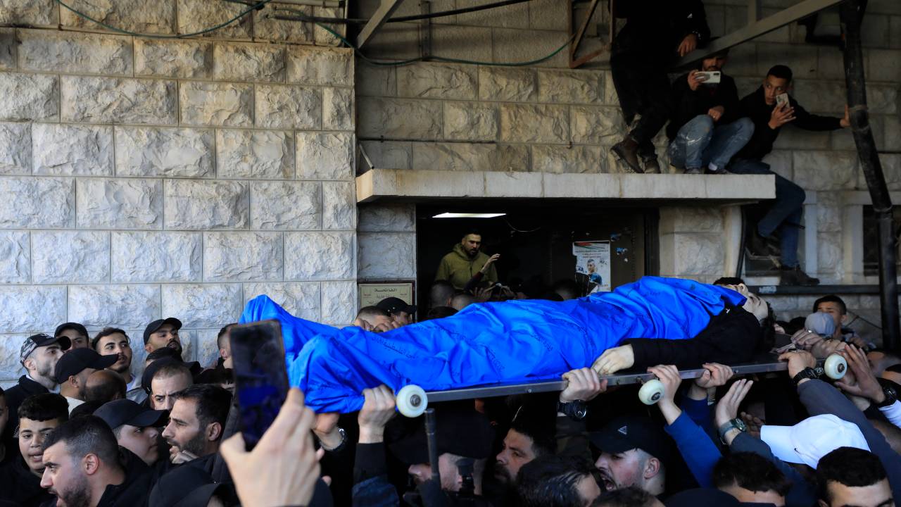 The body of a Palestinian killed in an Israeli raid is carried to a hospital in the occupied West Bank city of Nablus on February 22, 2023. - Israeli troops killed 10 Palestinians on February 22 in a raid, which the army said it carried out to find suspects, while more than 80 others were wounded, the Palestinian health ministry said. (Photo by ZAIN JAAFAR / AFP)