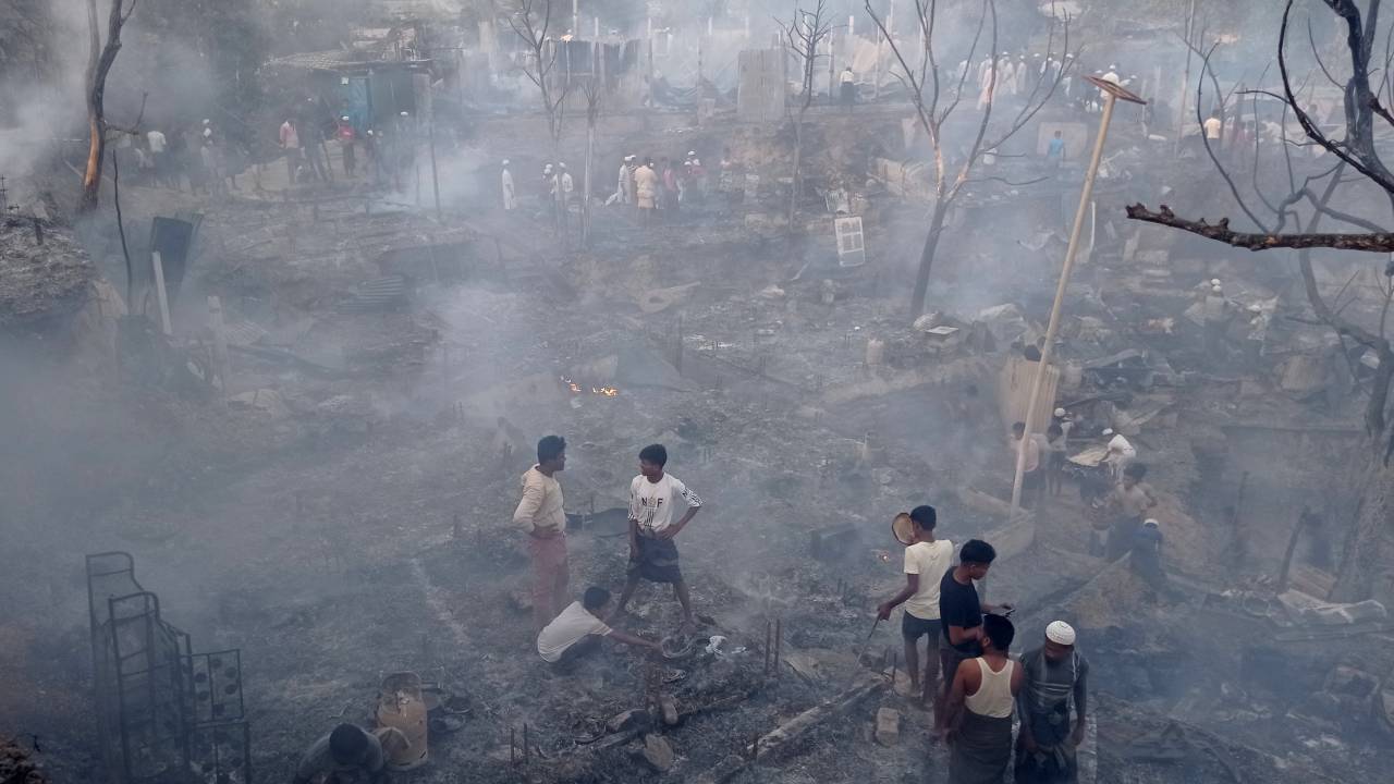 Rohingya refugees search for their belongings after a fire broke out in Balukhali refugee camp in Ukhia on March 5, 2023. - A major fire in a Rohingya refugee camp in Bangladesh's southeast Sunday burnt 2,000 shelters, leaving around 12,000 people homeless, an official said. (Photo by Tanbir Miraz / AFP)