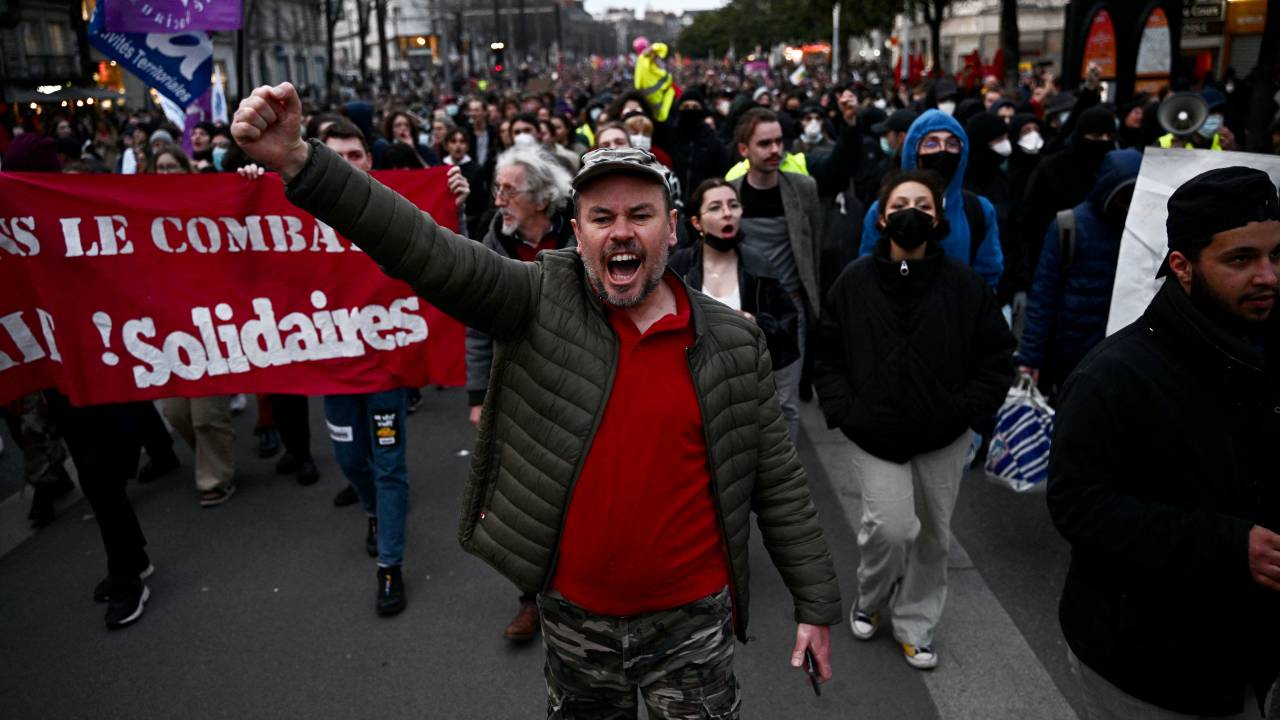 A protester gestures during a demonstration after the French government pushed a pensions reform through parliament without a vote, using the article 49.3 of the constitution, in Nantes, western France, on March 16, 2023. - The French president on March 16 rammed a controversial pension reform through parliament without a vote, deploying a rarely used constitutional power that risks inflaming protests. The move was an admission that his government lacked a majority in the National Assembly to pass the legislation to raise the retirement age from 62 to 64. (Photo by LOIC VENANCE / AFP)