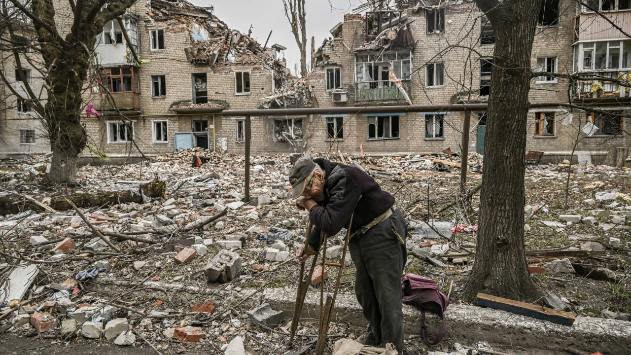 EDITORS NOTE: Graphic content / An eldery man collects wood from debris in front of a destroyed apartment building after a strike in the city of Avdiivka, Donetsk Oblast, on March 18, 2023. (Photo by Aris Messinis / AFP)