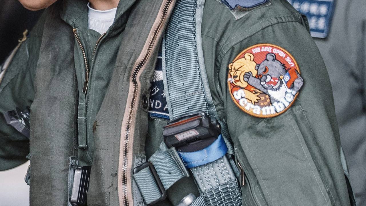 (FILES) This file handout photo from Taiwans Ministry of National Defense released on April 9, 2023 shows a Taiwanese air force fighter pilot, seen wearing an embroidered patch on his left shoulder depicting a Formosan black bear punching a character resembling Winnie-the-Pooh, beside his F-CK-1 indigenous defence fighter jet in an undisclosed location in Taiwan, as China conducts military exercises around the self-ruled island. - The iron-on patches being worn by some of Taiwan's air force pilots are a defiant message to Chinese leader Xi Jinping, often satirised for looking like Winnie the Pooh. (Photo by Handout / Taiwan's Ministry of National Defense / AFP) / RESTRICTED TO EDITORIAL USE - MANDATORY CREDIT "AFP PHOTO / TAIWAN'S MINISTRY OF NATIONAL DEFENSE"- NO MARKETING NO ADVERTISING CAMPAIGNS - DISTRIBUTED AS A SERVICE TO CLIENTS