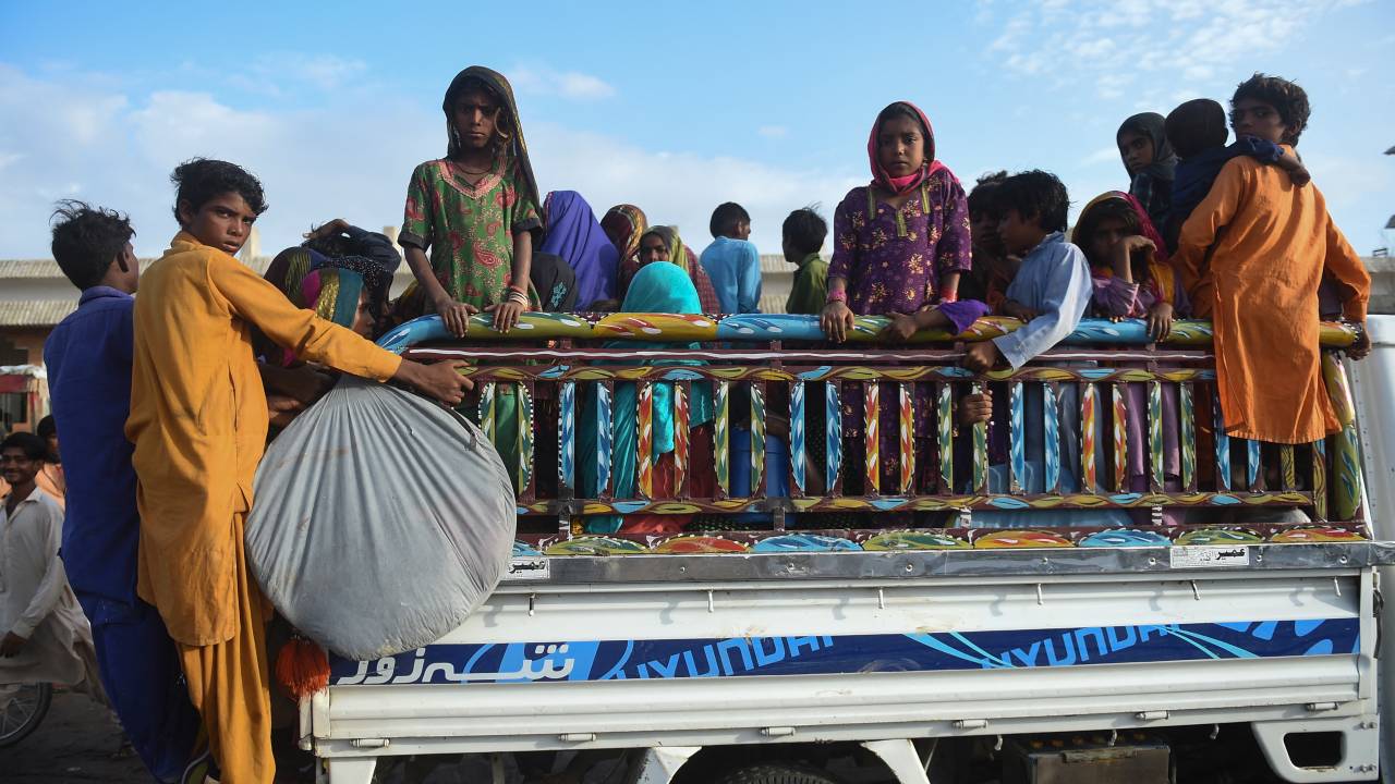 Cyclone evacuees arrive at a temporary shelter set at a school in Badin district of Pakistan's Sindh province on June 14, 2023, ahead of cyclone Biporjoy landfall. More than 100,000 people have been evacuated from the path of a fierce cyclone heading towards India and Pakistan, with forecasters warning on June 14 it could devastate homes and tear down power lines. (Photo by Rizwan TABASSUM / AFP)