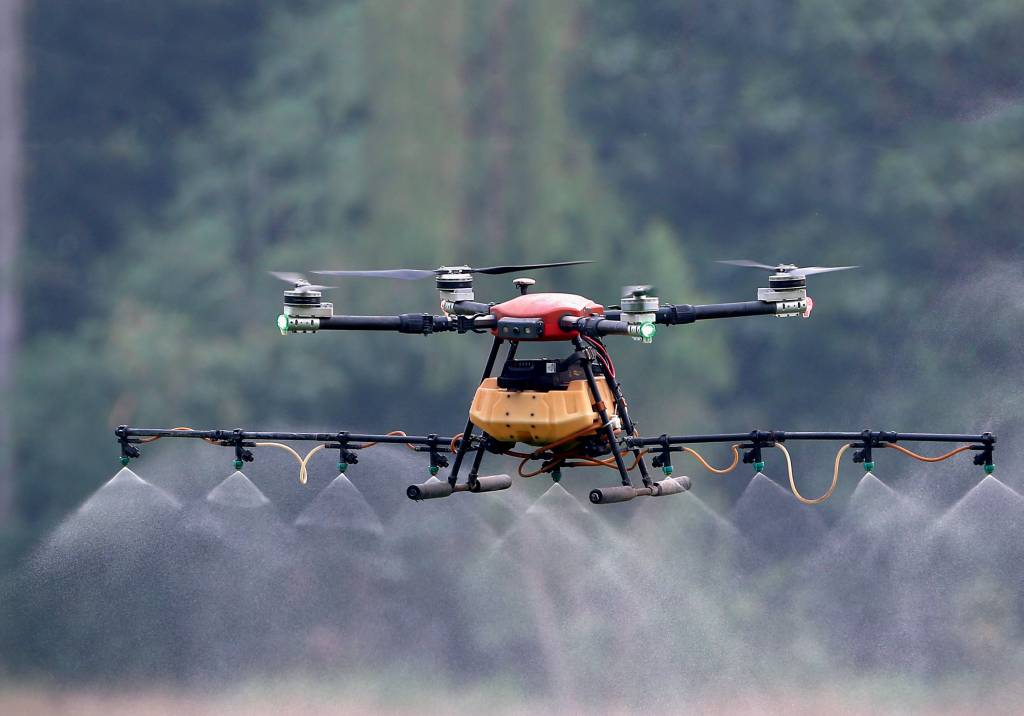 A drone sprays pesticide over a rice field in Nakhon Sawan NO CAMPO - Controle de pragas: dispositivo lança pesticida sobre plantação