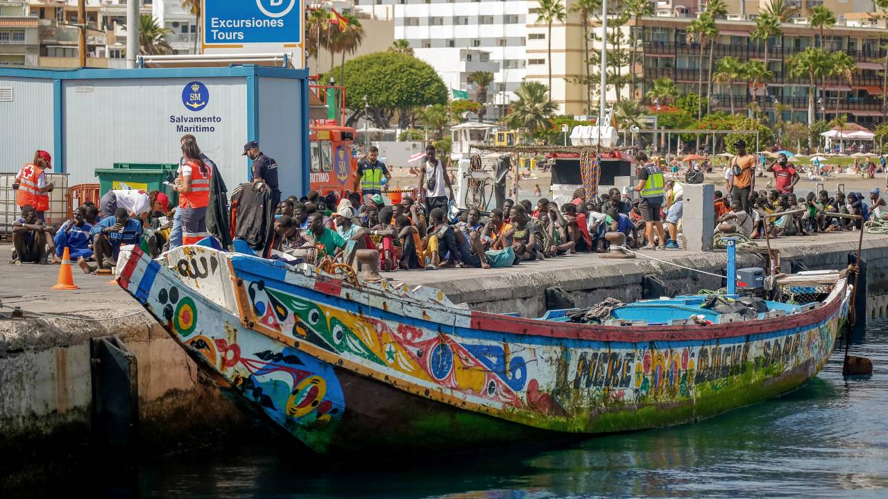 Migrants rest on the pier after disembarking from a 'cayuco' (wooden boat) following a rescue operation on July 4, 2023 at the port of Los Cristianos, in the municipality of Arona, in the south of Tenerife, on the Spanish Canary island of Tenerife. A boat with 157 migrants on board, two of them women, has arrived on July 4, 2023 at the port of Los Cristianos, in the municipality of Arona, in the south of Tenerife, on the Spanish Canary island of Tenerife, Red Cross sources have reported. The vessel was located through the Integrated External Surveillance System (SIVE) when it was about 8 miles from the Punta Rasca area, and the Maritime Rescue's vessel Salvamar Alpheratz came out to meet it. The Salvamar Alpheratz accompanied the boat to the port of Los Cristianos, where it arrived at around 4:00 p.m. on July 4, 2023. (Photo by DESIREE MARTIN / AFP)