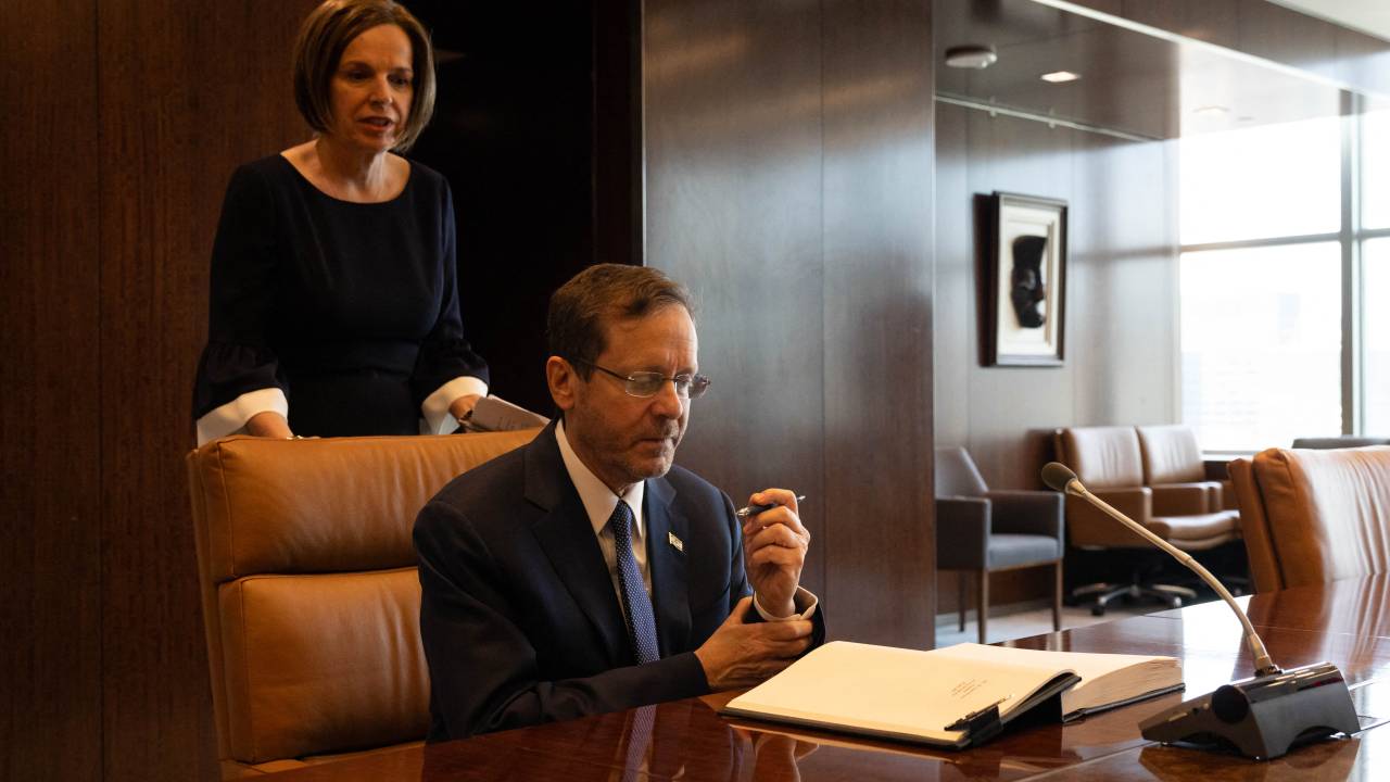 Israeli President Isaac Herzog signs a book during a meeting with UN Secretary-General Antonio Guterres, not pictured, at the UN headquarters in New York City on July 20, 2023. (Photo by Yuki IWAMURA / AFP)